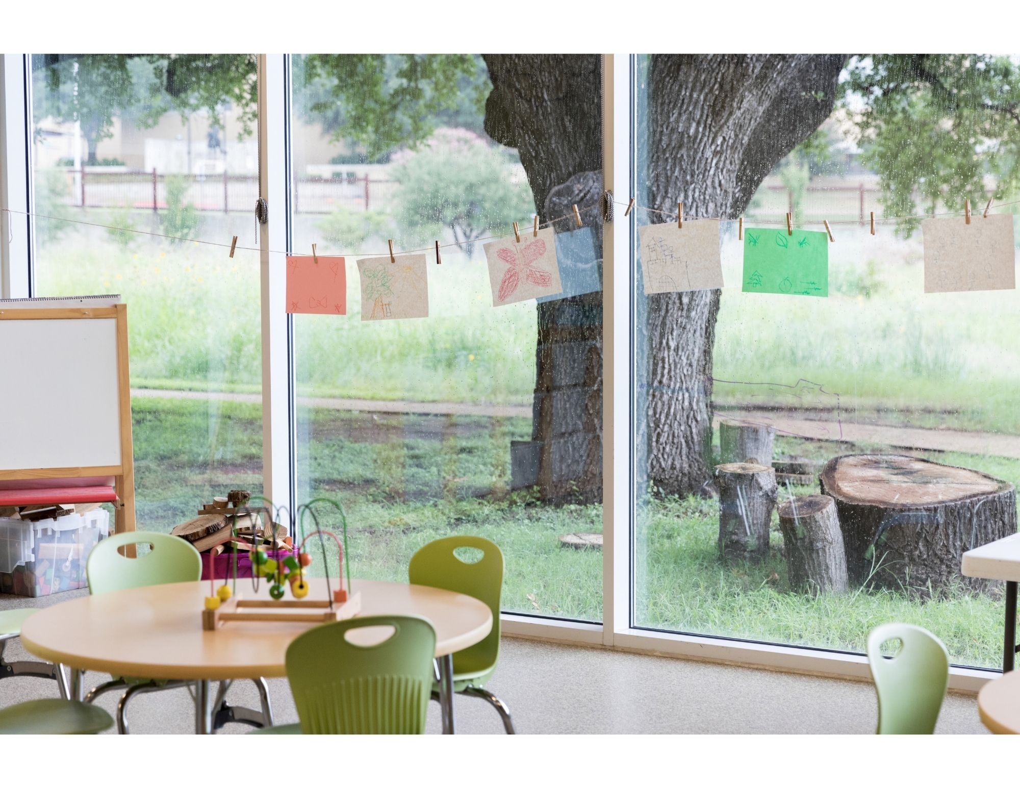 A bright classroom with children's artwork and nature views